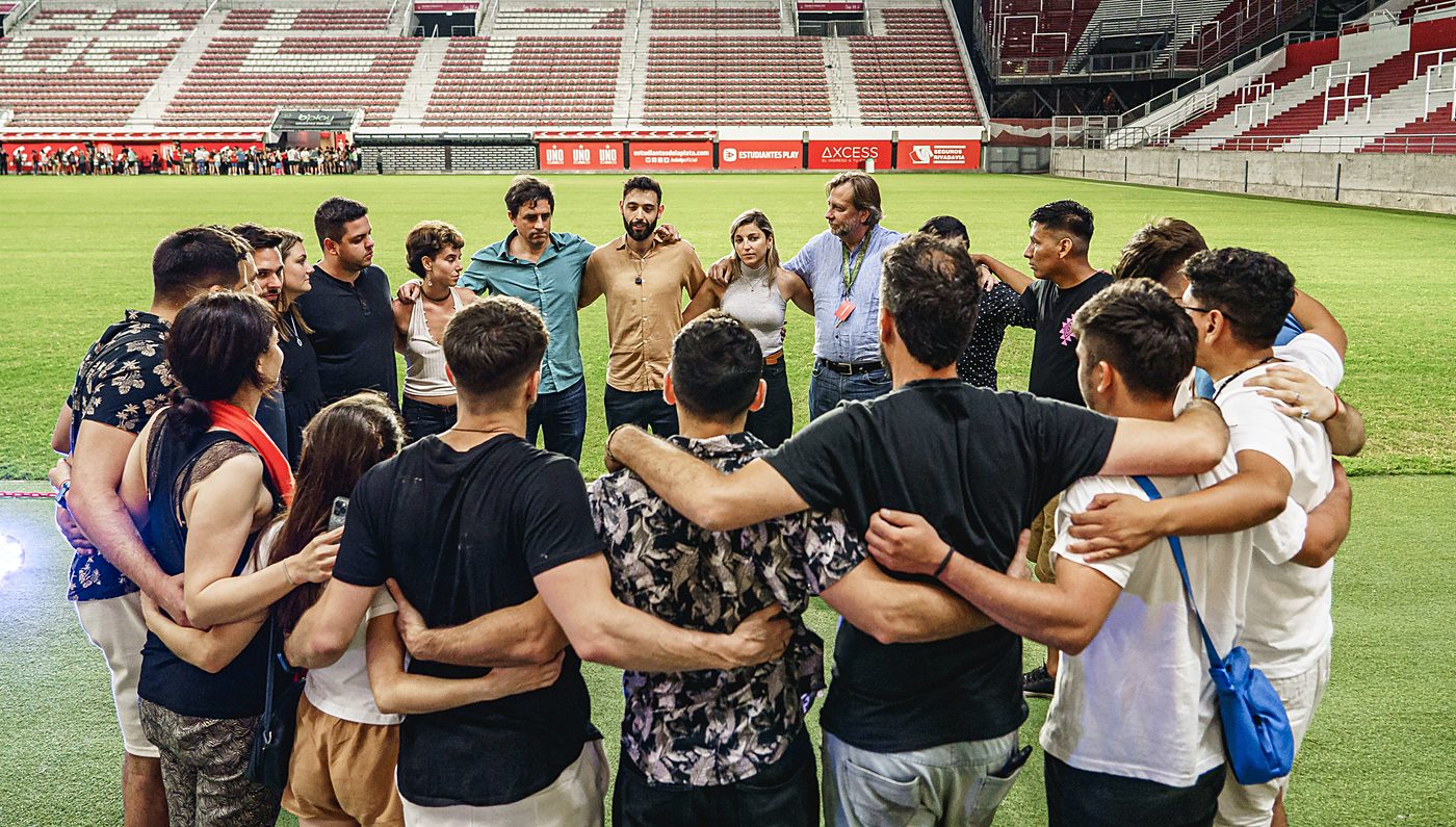 Círculo de cierre de una experiencia, con Matías Liberati y los participantes abrazados en el campo de juego
